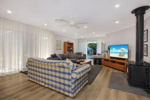 a living room with a couch and a flat screen tv at Vitamin Sea Pet Friendly in Hawks Nest