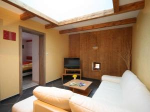 a living room with a white couch and a tv at Ferme Vosgienne Rénovée avec Confort et Nature pour 7 Pers, WiFi, Animaux Bienvenus - FR-1-589-190 in Vagney