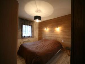 a bedroom with a bed in a room with wooden walls at Ferme Vosgienne Rénovée avec Confort et Nature pour 7 Pers, WiFi, Animaux Bienvenus - FR-1-589-190 in Vagney