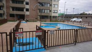 ein Swimmingpool in einem Gebäude mit einem Zaun in der Unterkunft Departamento Nueva Villarrica in Villarrica
