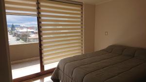ein Schlafzimmer mit einem Bett und einem großen Fenster in der Unterkunft Departamento Nueva Villarrica in Villarrica + 12 Fotos