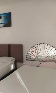 un letto bianco con un ventilatore sopra di Hotel los Abuelos a Jojutla de Juárez