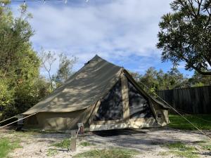 a canvas tent is set up in a yard at Luxury 6 metre Bell Tent & Outdoor Bathroom, WIFI, TV and firepit, in Coodanup