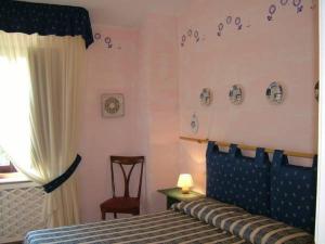 a bedroom with a bed with a blue headboard and a window at Agriturismo Le Macine in Silvi Marina