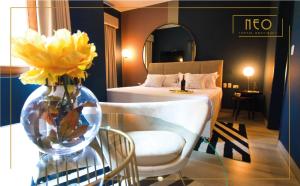 a hotel room with a bed and a vase with yellow flowers at Neo Hotel Boutique in Lima