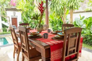 een eettafel met een rode tafelkleed en een vaas bij Villa Amiga in Sanur