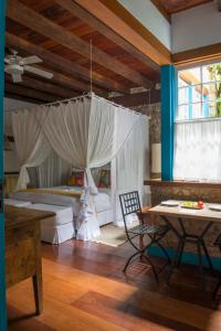 a living room with a bed and a table at Casa Turquesa - Maison D´Hôtes in Paraty