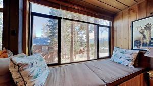 a bed in a room with a large window at Lakeview 826 Condo #532 Condo in Mammoth Lakes