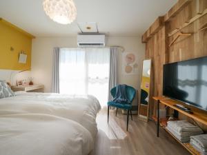 札幌的住宿－Hotel Flourish 67，一间卧室配有一张床和一台平面电视