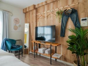 a bedroom with a flat screen tv on a wooden wall at Hotel Flourish 67 in Sapporo