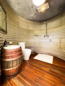 a bathroom with a toilet and a sink in a wooden floor at Luxury 6 metre Bell Tent & Outdoor Bathroom, WIFI, TV and firepit, in Coodanup