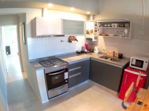 a small kitchen with a stove and a sink at Alumine in Puerto Madryn