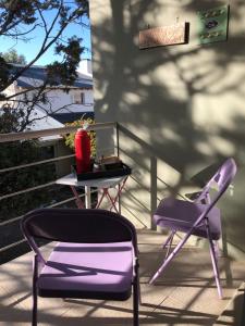 a purple chair and a table on a balcony at Alumine in Puerto Madryn