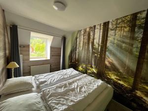 een slaapkamer met een bed en een groot schilderij aan de muur bij Farm with indoor pool and bubble bath in Houyet
