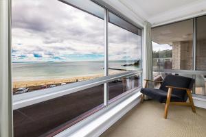 a room with a large window with a view of the beach at El Sandi, Unit 10, 14-18 North Street in Forster