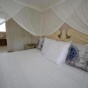 a white bed with two pillows in a bedroom at La Voyageur Waterfront Apartments by AVI in Akaroa