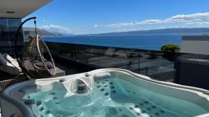 a hot tub on a balcony with a view of the ocean at Liberty Living Apartments in Split