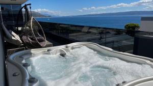 a jacuzzi tub on a balcony with the ocean at Liberty Living Apartments in Split