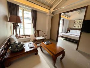 una sala de estar con una habitación con una cama y una mesa en Heritage Lodge, en Hong Kong