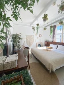 sypialnia z łóżkiem, stołem i roślinami w obiekcie Heritage Lodge w Hongkongu