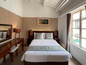 a bedroom with a bed and a desk and window at 饒宗頤文化館 - 翠雅山房 in Hong Kong