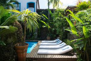 a row of chaise lounges next to a pool at Casa Turquesa - Maison D´Hôtes in Paraty