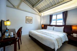 a bedroom with a bed and a desk and a window at 饒宗頤文化館 - 翠雅山房 in Hong Kong