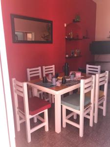 图伊海Entre Sueños的一张餐桌和椅子,墙上是红色的墙