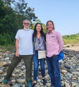 3 personnes posant pour une photo sur une plage rocheuse dans l'établissement Anaconda Lodge Ecuador, à Ahuano