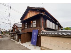 um edifício com um sinal azul em frente em Large family accommodation Tsuji family - Vacation STAY 11311v em Mitoyo