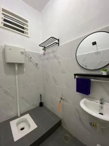 a bathroom with a sink and a toilet and a mirror at De Jara Guesthouse, Kuala Dungun in Dungun +33 photos