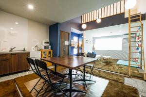 Il comprend une cuisine et une salle à manger avec une table et des chaises en bois. dans l'établissement Tiz wan 岩屋あわじ, à Awaji