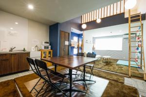 a kitchen and dining room with a wooden table and chairs at Tiz wan 岩屋あわじ in Awaji