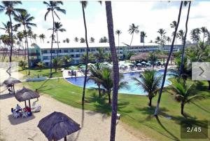Una vista de un resort con piscina y palmeras. en Ancorar flat resort- porto de galinhas, en Porto de Galinhas 61 fotos más