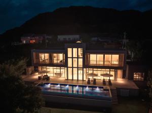 ein großes Haus mit Pool in der Nacht in der Unterkunft Shingetsuann Shirahama in Shirahama