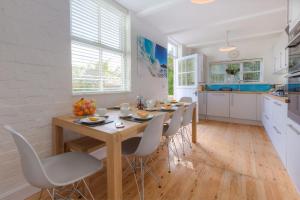 Una cocina con una mesa y sillas en una cocina. en Sea Dream, en St Ives
