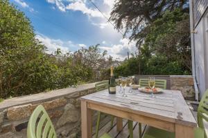 una mesa de madera con una botella de vino y copas de vino en Sea Dream, en St Ives