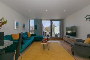 Una sala de estar con un sofá azul y un televisor en Sea Glass, en Carbis Bay