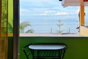 een stoel op een balkon met uitzicht op de oceaan bij RedDoorz Plus @ Galucksea Beach Resort in Caore