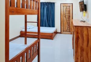 Caore的住宿－RedDoorz Plus @ Galucksea Beach Resort，一间卧室设有两张双层床和水槽