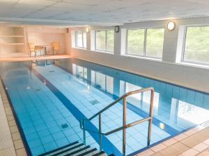 uma grande piscina interior com azulejos azuis em Residenz Passat Cuxhaven 4 em Cuxhaven