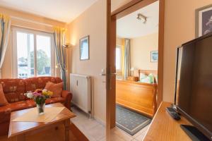 ein Wohnzimmer mit Couch und Fernseher in der Unterkunft Villa Linde in Göhren