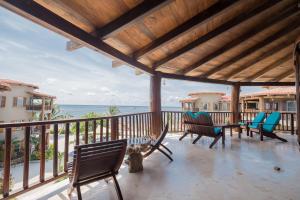 a porch with chairs and a view of the ocean at Indigo Belize 3C Condo in San Pedro