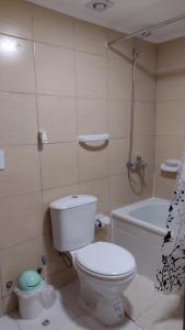 a bathroom with a white toilet and a bath tub at Tan Ushuaia in Ushuaia +8 photos