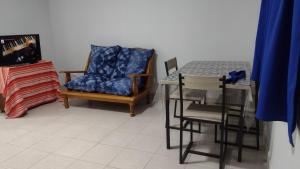 a living room with a chair and a table with a blue pillow at Tan Ushuaia in Ushuaia