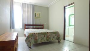 拉巴拉德纳圣米格尔Casarão Com 3 suítes, 2 quartos, Piscina, Praia Perto的卧室里有一张床，一张桌子和一面镜子 更多34张照片