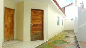 拉巴拉德纳圣米格尔Casarão Com 3 suítes, 2 quartos, Piscina, Praia Perto的走廊设有木门,铺有瓷砖地板