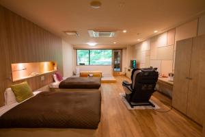 小樽市にあるOtaru Asari Classe Hotelのベッド2台、ソファ、キッチンが備わる客室です。