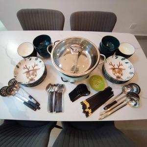 uma mesa com pratos e utensílios em W39WarmStay@GoldenHills/NightMarket/4R/BBQ em Brinchang