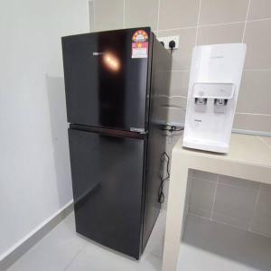 einen schwarzen Kühlschrank in einer Küche neben einer Theke in der Unterkunft W39WarmStay@GoldenHills/NightMarket/4R/BBQ in Brinchang